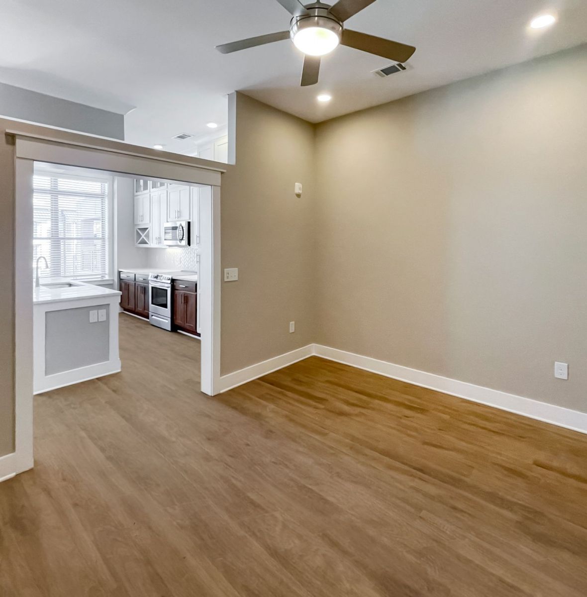 Luxury Charlotte apartment interior with vinyl plank, kitchen island, and ceiling fan