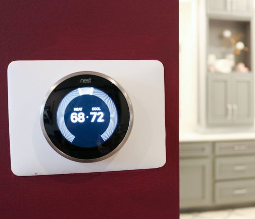 Nest digitally programmable thermostat on apartment wall