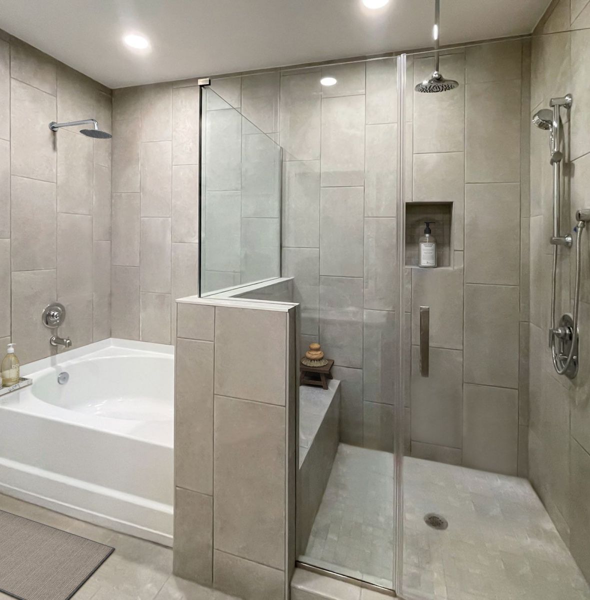 Luxury apartment bathroom with frameless glass shower, rain showerheads, and tub